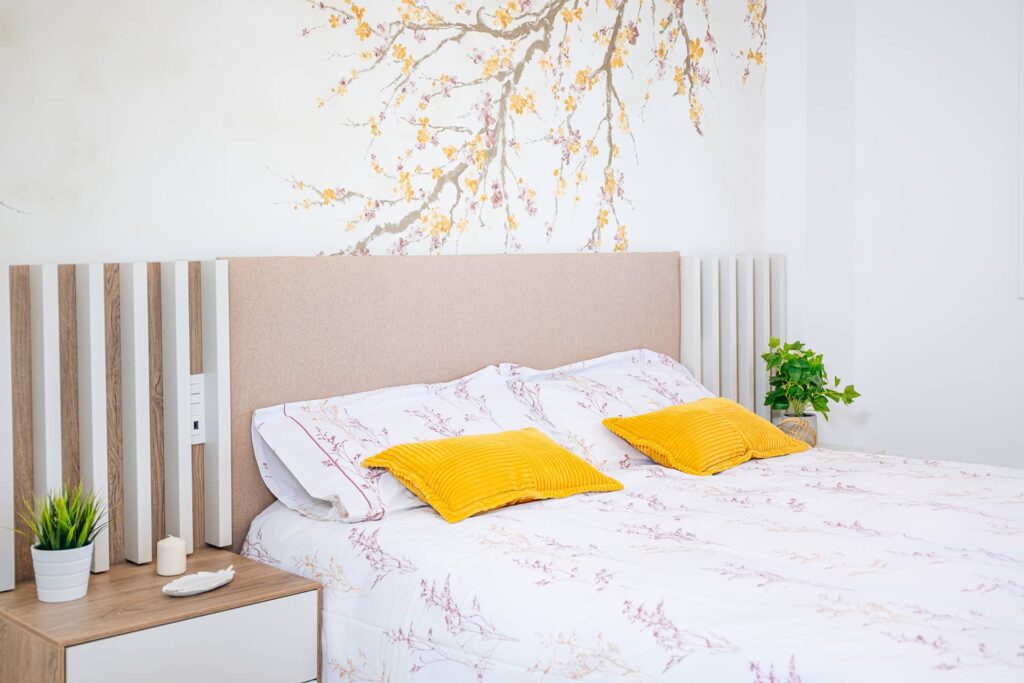 Dormitorio renovado con cabecero, papel pintado y mobiliario